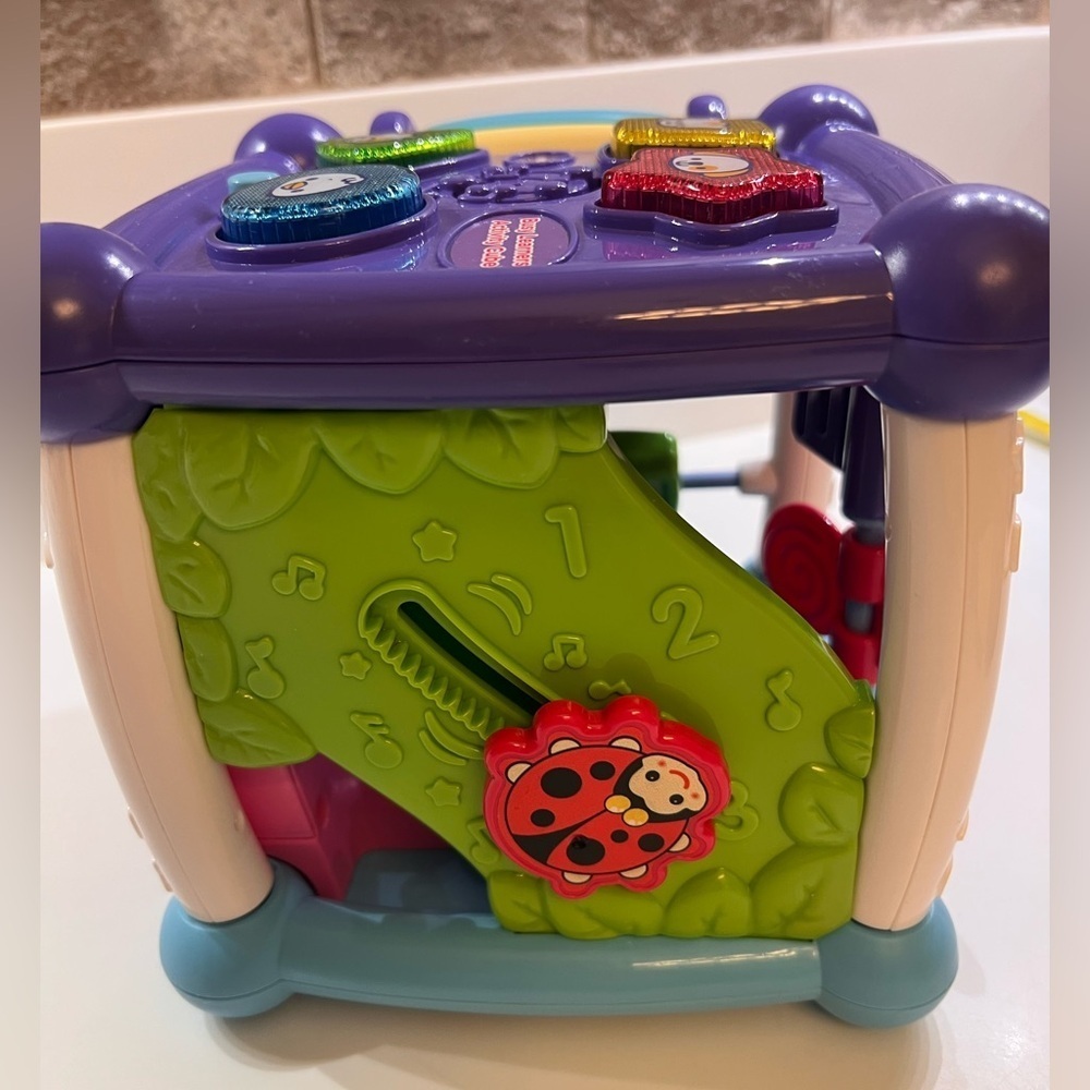 V TECH BUSY LEARNERS ACTIVITY CUBE WITH FIVE SIDES OF PLAY. 6-1/2” Square